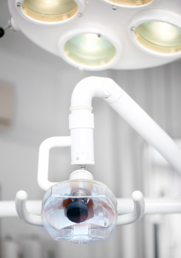 Dentist chair and light stand against tools and equipment background